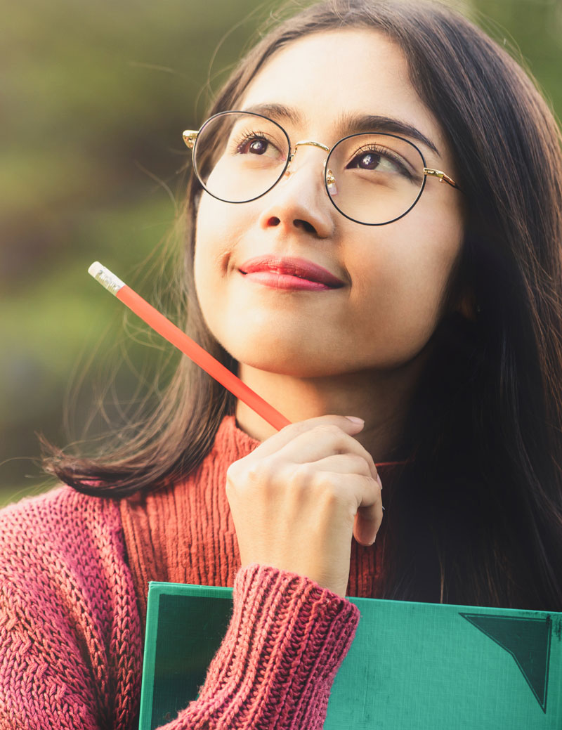 Girl with pad and pencil thinking